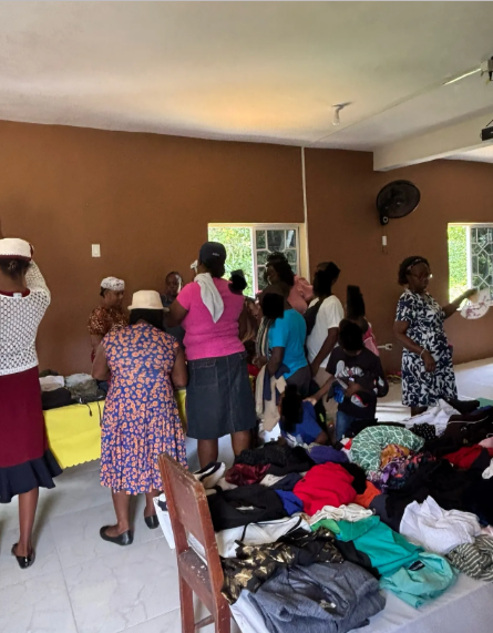Women gathered around tables of donated clothing at a community outreach