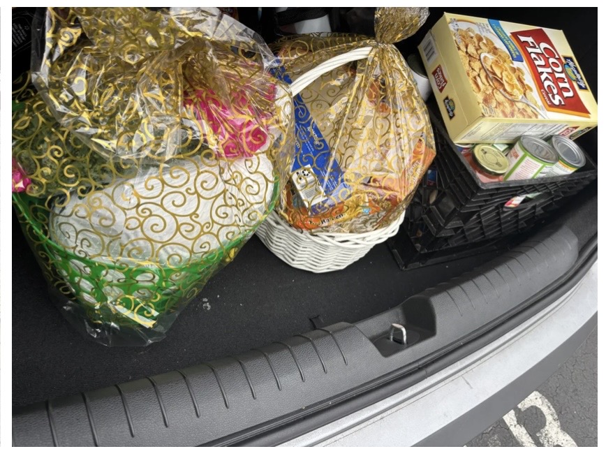 Thanksgiving baskets and food packed in a car trunk for local family delivery